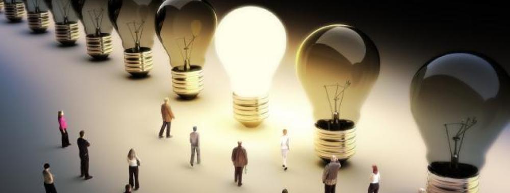 people walking around large light bulbs with one lightbulb lit